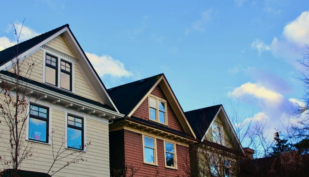 View of row housing rooftops against a blue sky, representing BC Housing and rezoning.